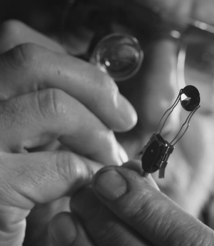 A man is working on a small piece of jewelry.