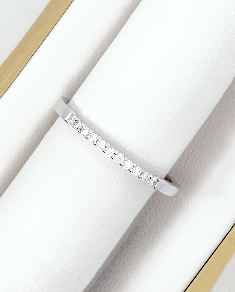 A white gold diamond band ring in a box.