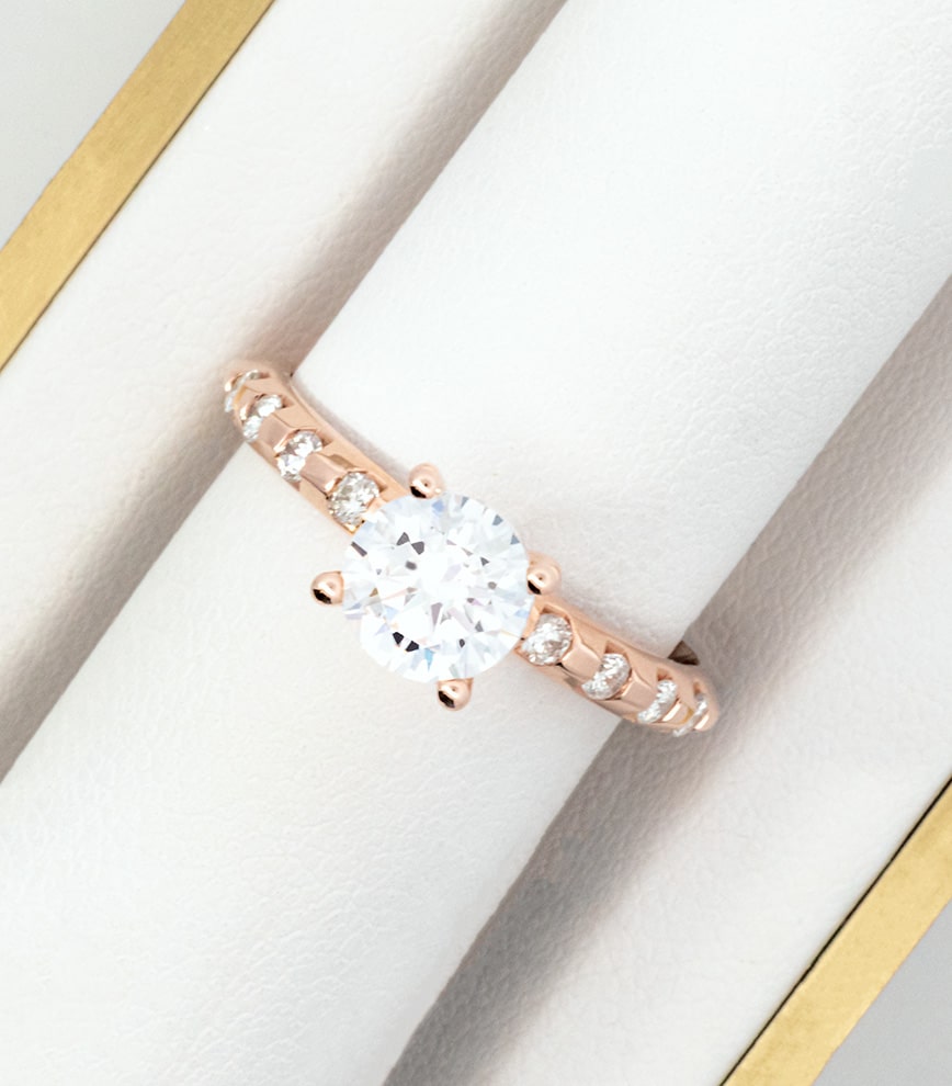 A rose gold engagement ring with a diamond in the center.