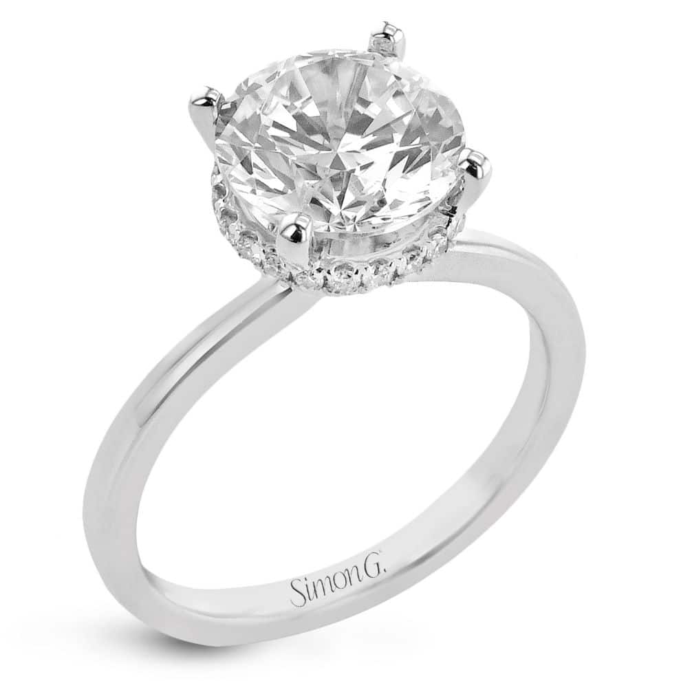 A white gold engagement ring with a round cut diamond.