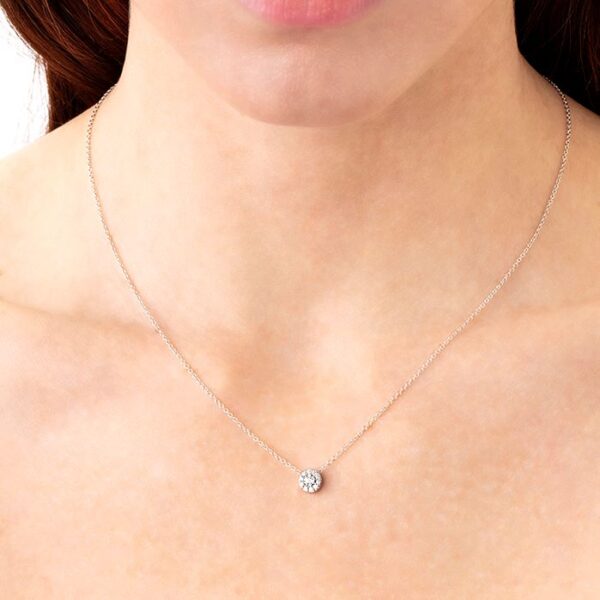 A woman wearing a necklace with a diamond pendant.
