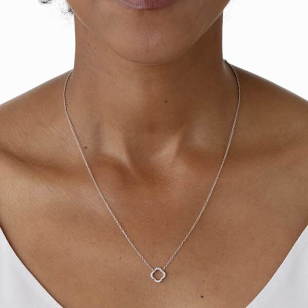 A woman wearing a necklace with a circle pendant.