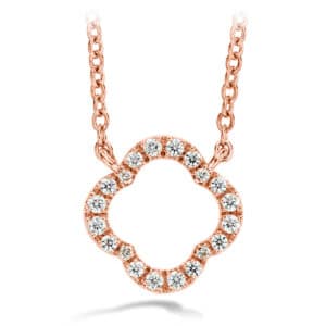 A rose gold clover necklace with diamonds.