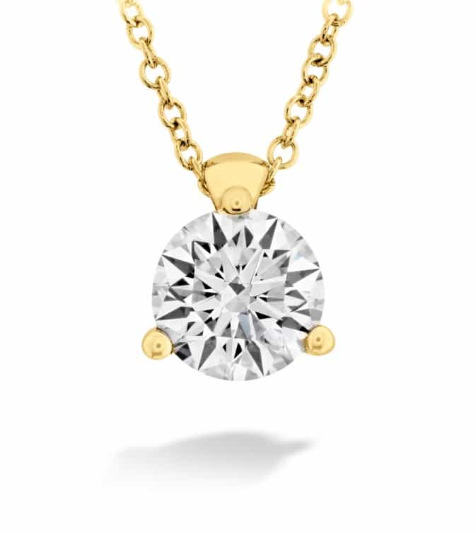 A yellow gold pendant with a round brilliant cut diamond.