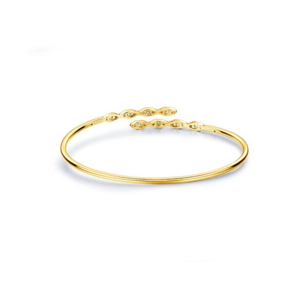 A yellow gold bangle bracelet with two small stones.