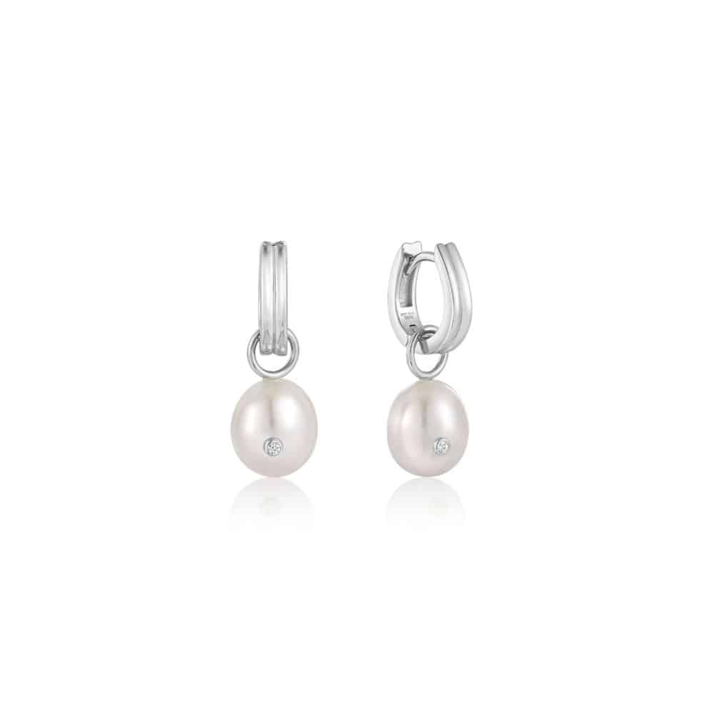 A pair of pearl and diamond earrings on a white background.