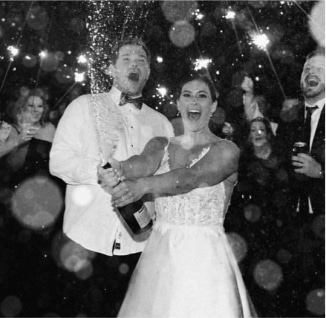 A black and white photo of a bride and groom with sparklers.