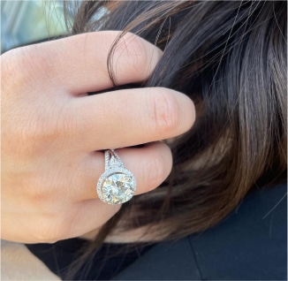 A woman's hand holding a diamond engagement ring.